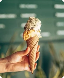 Cucurucho de helado artesanal sostenido en la mano