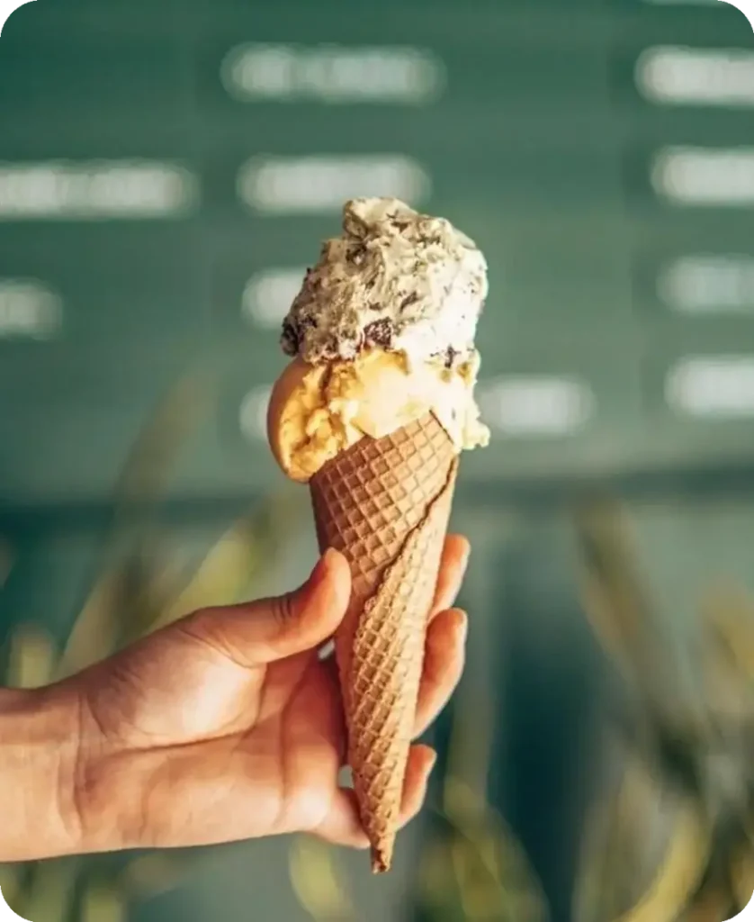 Cucurucho de helado artesanal sostenido en la mano