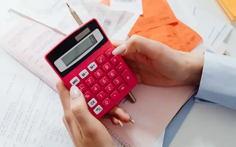 Manos con una calculadora y tickets de compra: los números que definen si una heladería es rentable