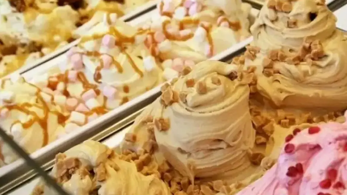 Instituto de Formación del Helado Artesanal 2 Vitrina de helado artesanal con baldes decorados: crema, dulce de leche y frutos rojos