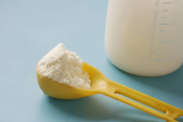 Una medida de leche en polvo junto a una botella de leche: la fuente habitual de sólidos lácteos no grasos