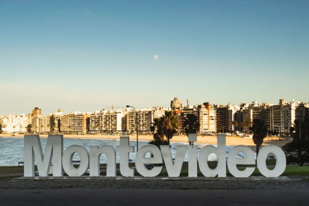 Las letras de Montevideo sobre la rambla, con la ciudad y el Río de la Plata de fondo