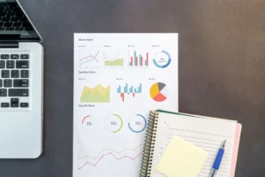 Notebook, gráficos impresos y cuaderno de notas sobre el escritorio: el plan de negocios de una heladería