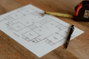 Un plano de planta con cinta métrica y lapicera: el layout de la heladería se decide en el papel