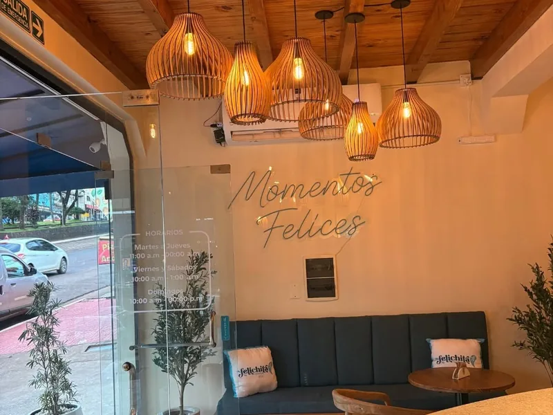 Interior de Felichità con lámparas de madera y el neón «Momentos felices»